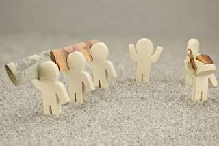 Foto: Kleine Figuren mit Geldscheinen und Münzen